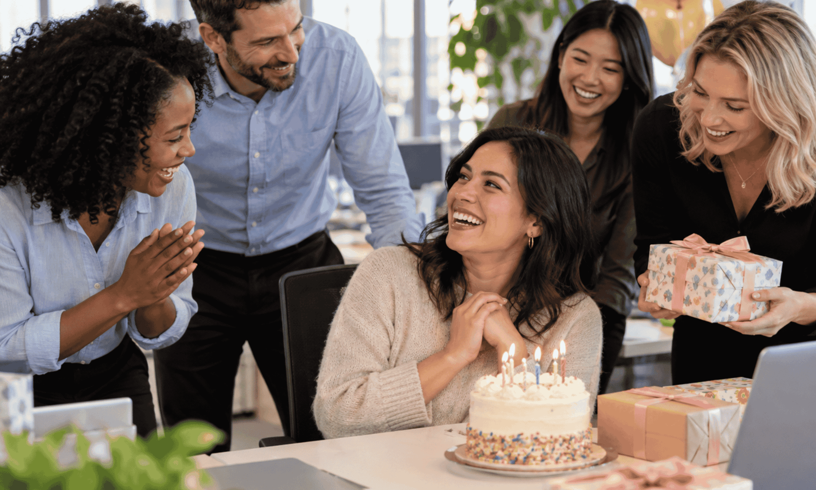 coworkers celebrating a birthday at office with cake gifts and happy colleague making work more enjoyable